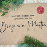 Flat lay of customised Santa letter and envelope on festive background